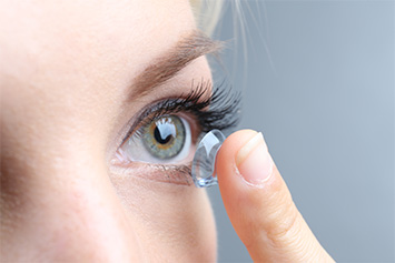 Woman putting on contact lenses