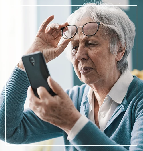 Senior woman having vision problems, she can't read the messages on her smartphone
